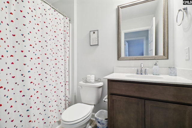 bathroom with curtained shower, vanity, and toilet