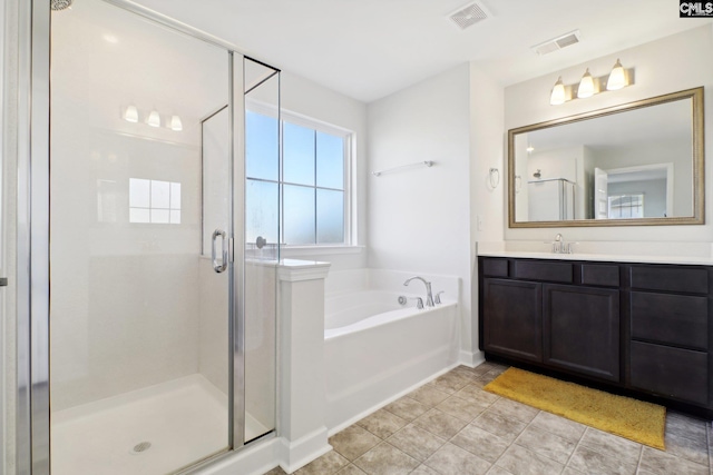 bathroom with vanity, tile patterned flooring, and plus walk in shower