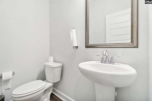 bathroom with hardwood / wood-style flooring and toilet