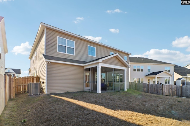 back of property with a sunroom, a yard, and cooling unit