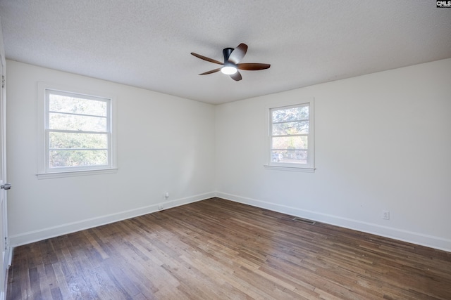 empty room featuring hardwood / wood-style flooring, a textured ceiling, and a wealth of natural light