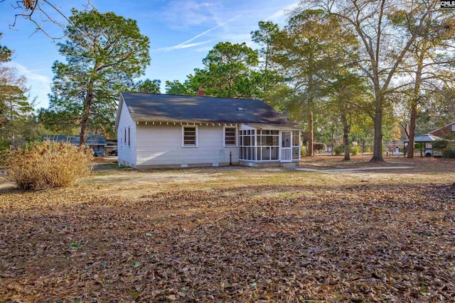 rear view of property featuring a sunroom