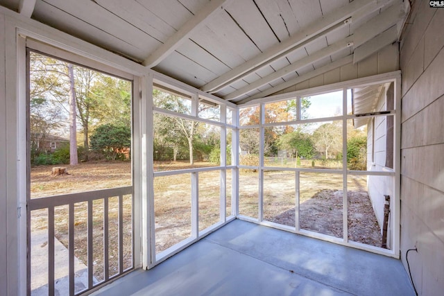 unfurnished sunroom featuring vaulted ceiling with beams and wooden ceiling