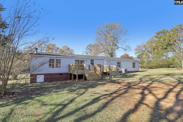 back of property with a deck and a yard