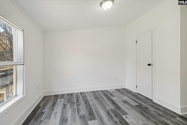 unfurnished room featuring dark hardwood / wood-style flooring, plenty of natural light, and crown molding