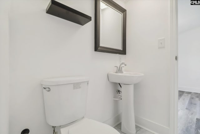 bathroom featuring hardwood / wood-style floors and toilet