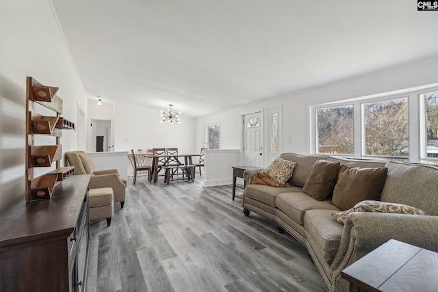 living room with a chandelier, lofted ceiling, and hardwood / wood-style flooring