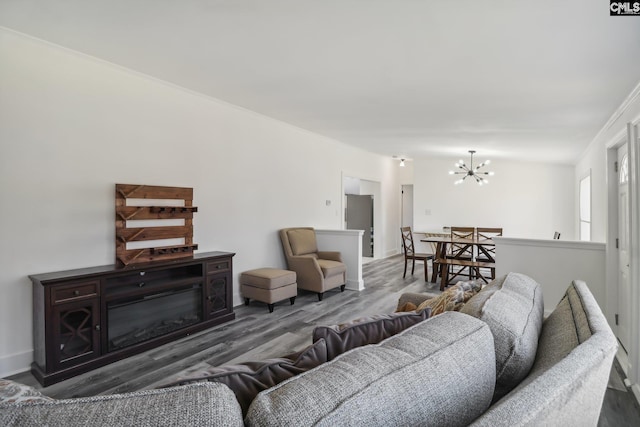 living room with hardwood / wood-style floors, crown molding, and an inviting chandelier