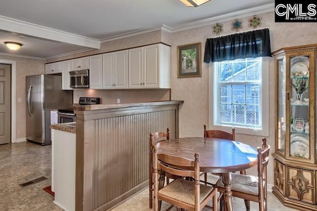 kitchen with kitchen peninsula, white cabinetry, stainless steel appliances, and ornamental molding