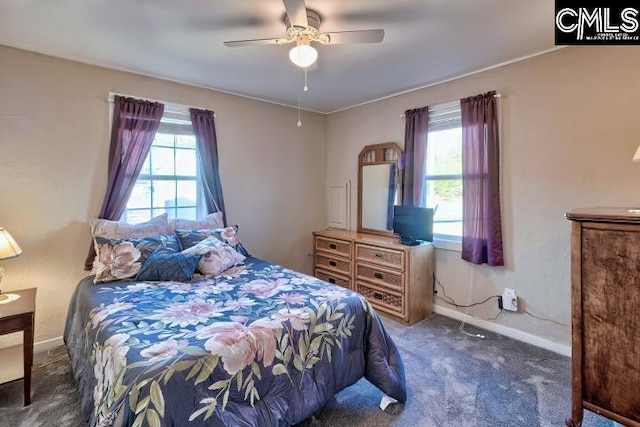 carpeted bedroom featuring multiple windows and ceiling fan