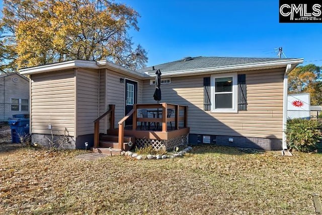 rear view of property featuring a lawn