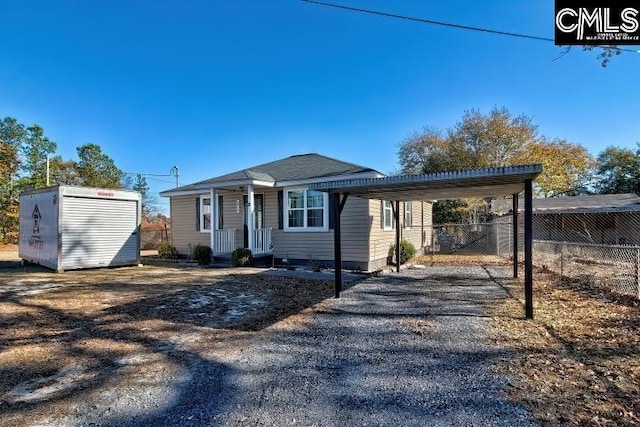 view of front of property featuring a shed and a carport