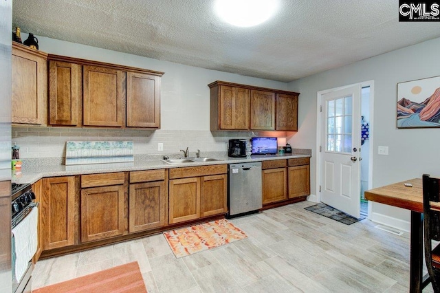 kitchen with dishwasher, sink, tasteful backsplash, a textured ceiling, and white range with gas cooktop