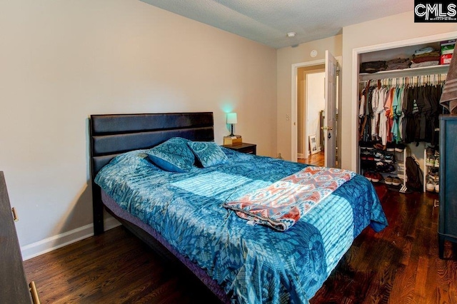 bedroom with dark wood-type flooring and a closet