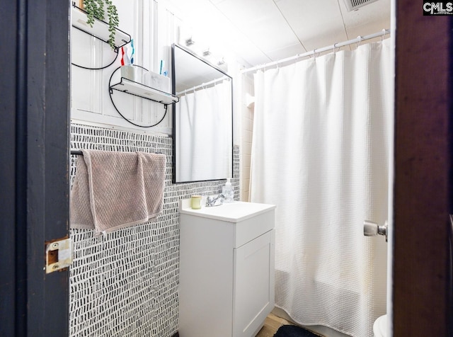 bathroom featuring vanity, tile walls, and walk in shower