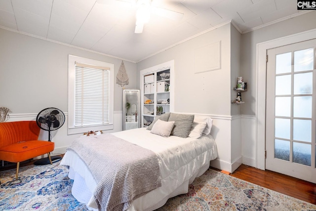 bedroom with hardwood / wood-style floors, ceiling fan, and crown molding