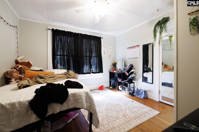 bedroom featuring ceiling fan, wood-type flooring, and ornamental molding