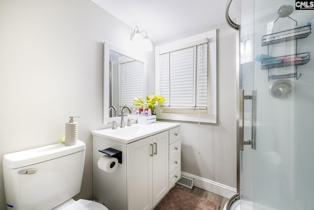 bathroom with toilet, a shower with door, vanity, and hardwood / wood-style flooring