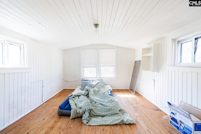 living area with wood walls, lofted ceiling, light hardwood / wood-style flooring, built in shelves, and wood ceiling