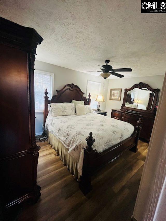 bedroom featuring hardwood / wood-style floors, a textured ceiling, and ceiling fan