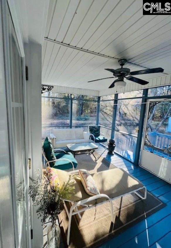 sunroom / solarium featuring plenty of natural light and ceiling fan