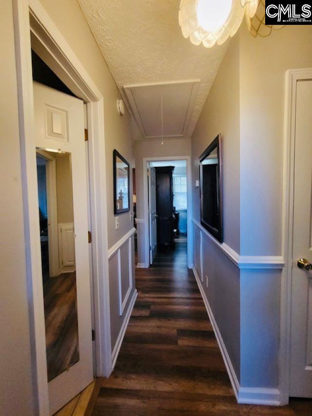corridor featuring a textured ceiling and dark wood-type flooring