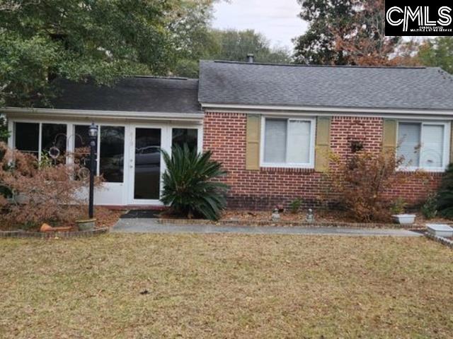 view of front of home with a sunroom and a front lawn