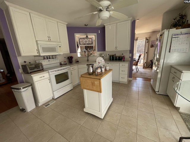 kitchen featuring white cabinets, white appliances, a kitchen island, and backsplash