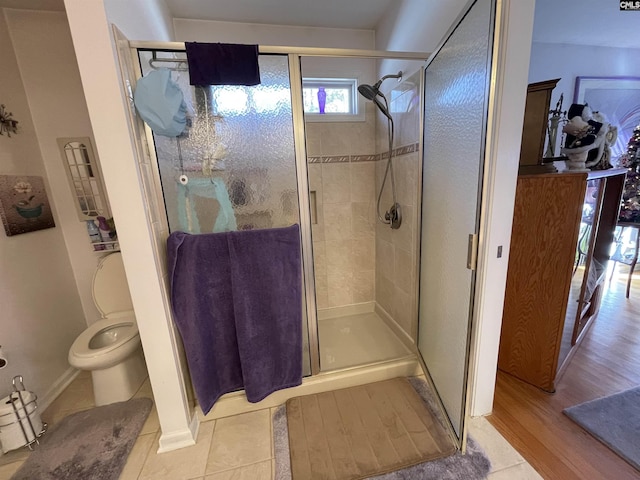 bathroom featuring toilet, wood-type flooring, and walk in shower