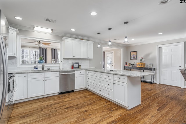 kitchen featuring white cabinets, sink, kitchen peninsula, wood-type flooring, and stainless steel appliances