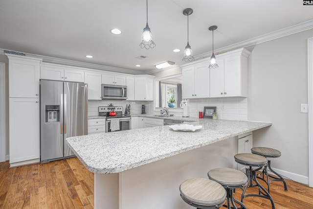 kitchen featuring white cabinets, appliances with stainless steel finishes, and light hardwood / wood-style floors