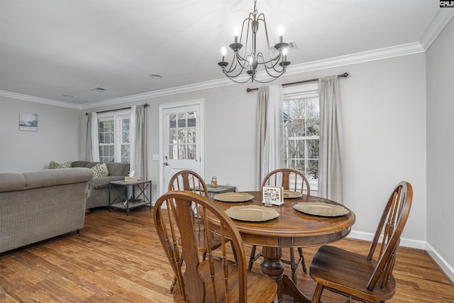 dining space with a chandelier, light wood-type flooring, and a wealth of natural light