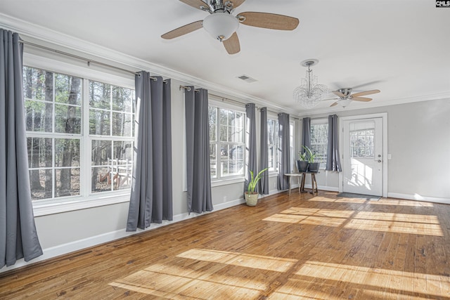 interior space featuring plenty of natural light, wood-type flooring, and ornamental molding