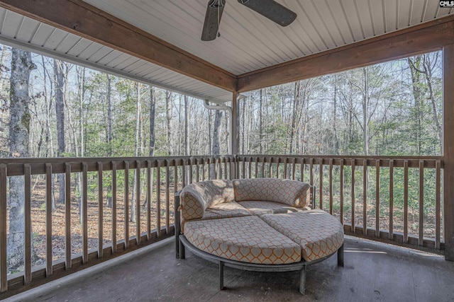 sunroom featuring ceiling fan, plenty of natural light, and beamed ceiling