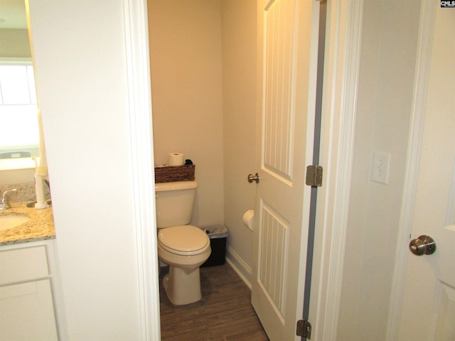 bathroom with hardwood / wood-style flooring, vanity, and toilet