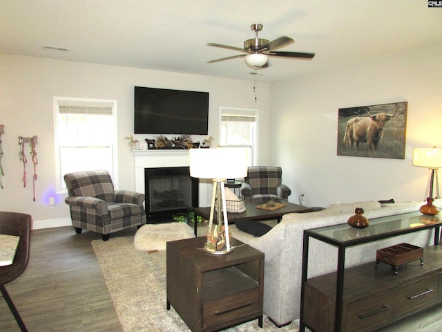 living room featuring ceiling fan and dark wood-type flooring