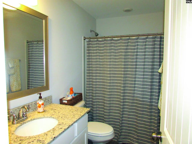 bathroom with a shower with shower curtain, vanity, and toilet