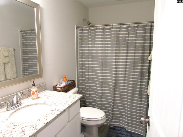 bathroom with walk in shower, vanity, and toilet