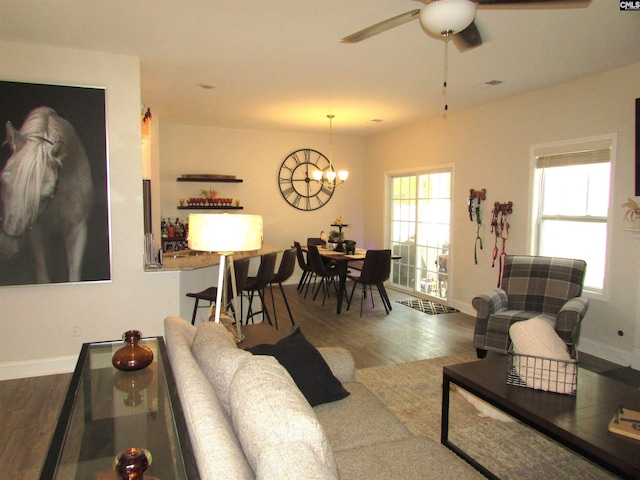 living room featuring dark hardwood / wood-style flooring and ceiling fan with notable chandelier