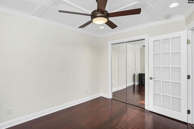 unfurnished bedroom with dark hardwood / wood-style flooring, coffered ceiling, ceiling fan, crown molding, and a closet