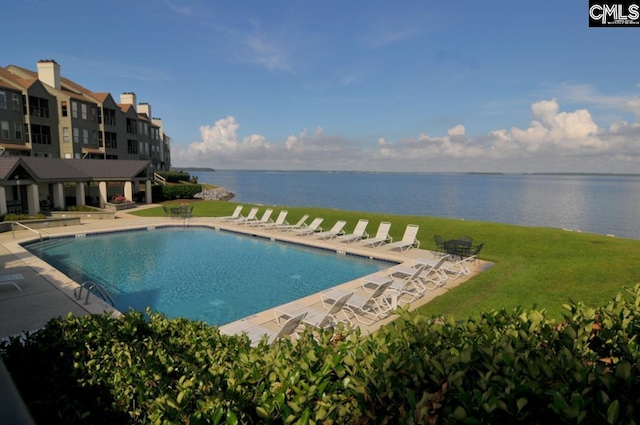 view of pool featuring a lawn, a patio area, and a water view