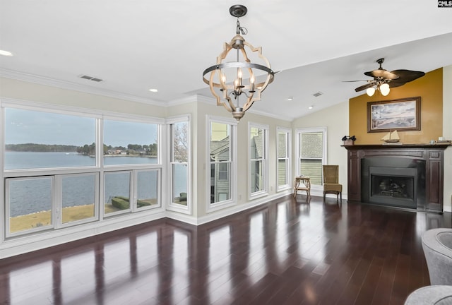 living room with a water view, dark wood-type flooring, a wealth of natural light, and vaulted ceiling