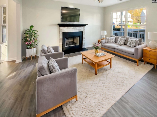 living room with a fireplace, radiator heating unit, and dark wood-type flooring