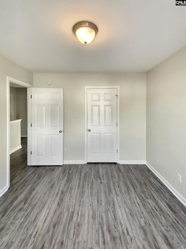 unfurnished bedroom featuring dark hardwood / wood-style flooring and a closet