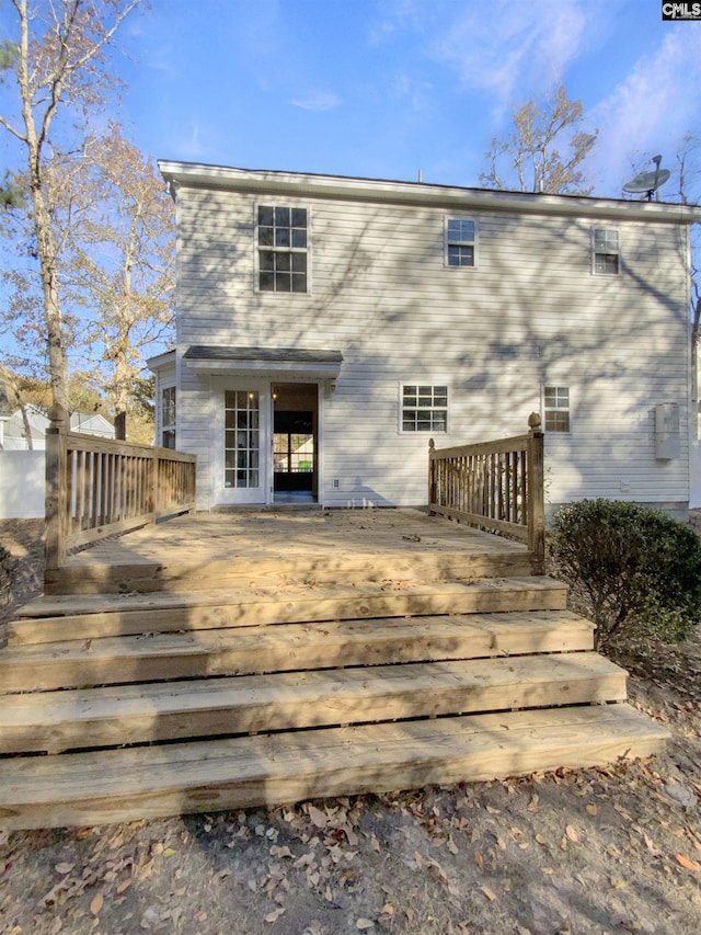 rear view of property featuring a wooden deck