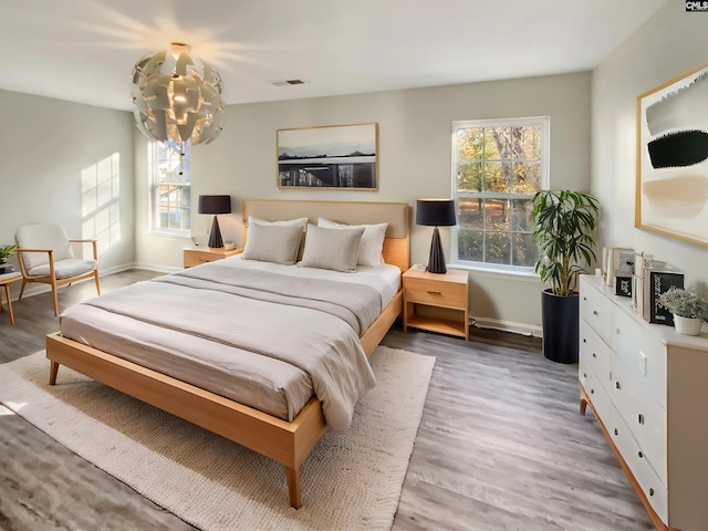 bedroom with hardwood / wood-style floors and a chandelier