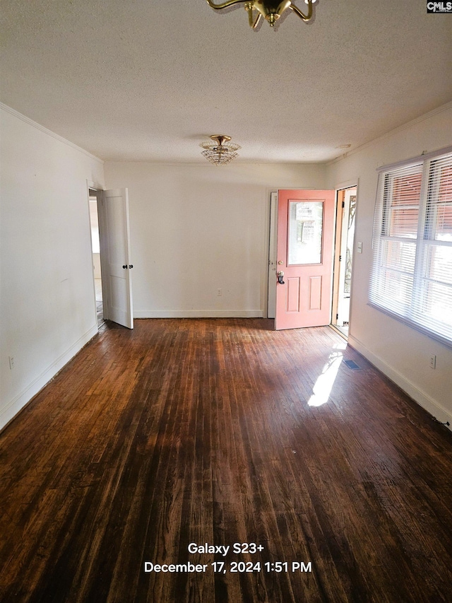 empty room featuring a textured ceiling and dark hardwood / wood-style floors