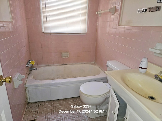 bathroom featuring vanity, toilet, and tile walls