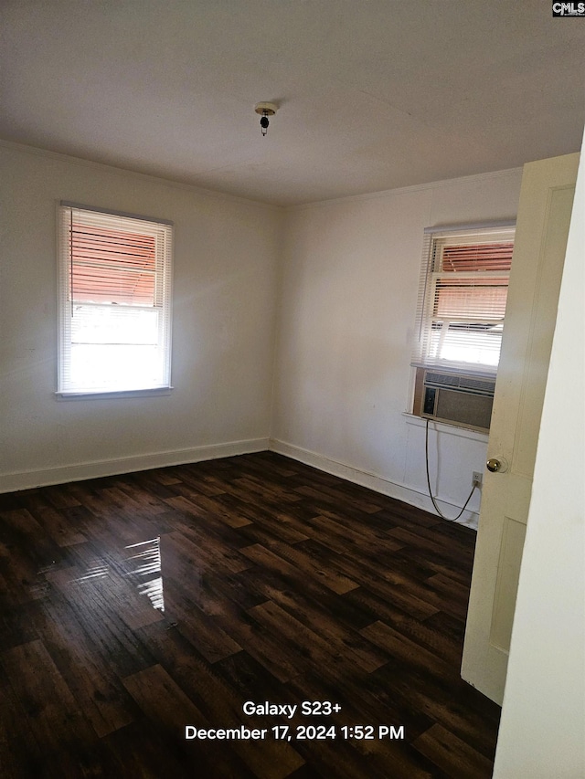 empty room featuring cooling unit and dark wood-type flooring