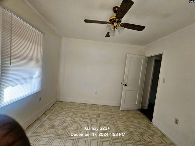 empty room with ceiling fan and crown molding